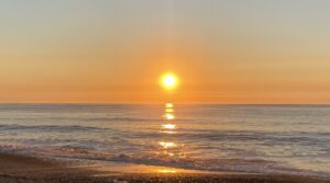 Sunrise from the beach reflecting on the waves