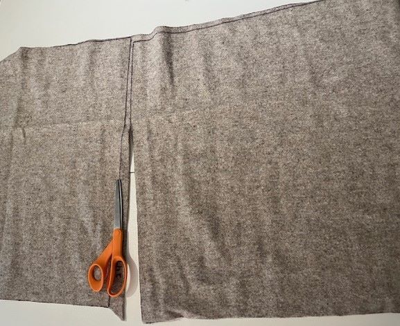 Wool fabric on cutting table with scissors