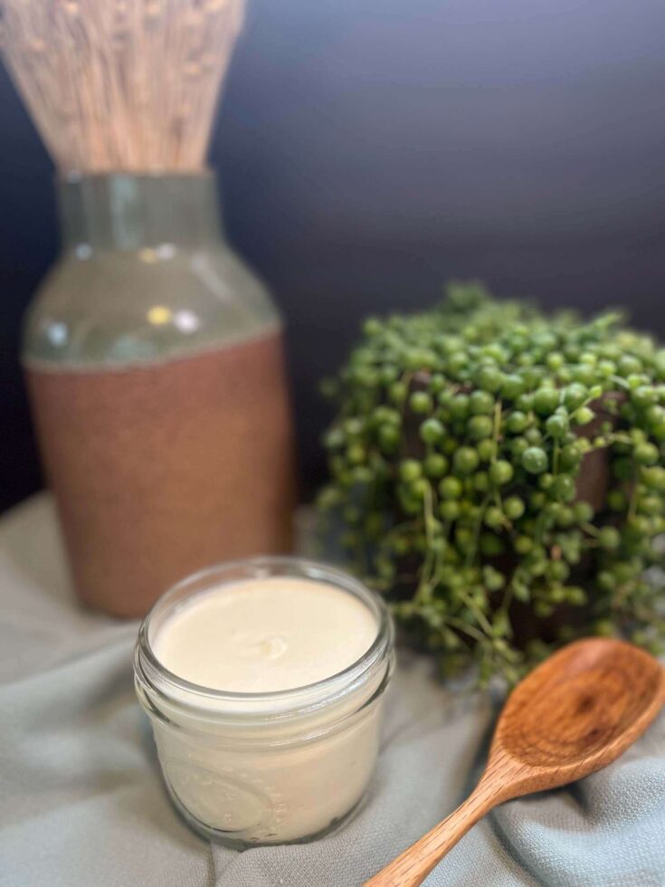Tallow Balm next to green plant
