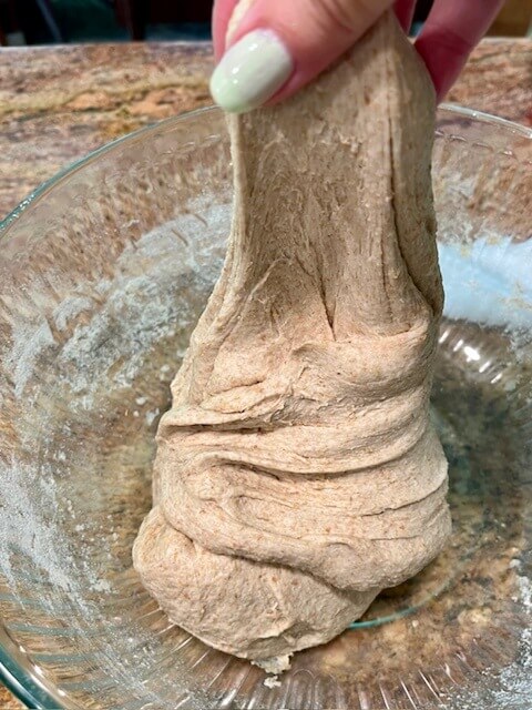 dough in glass bowl doing stretch and folds