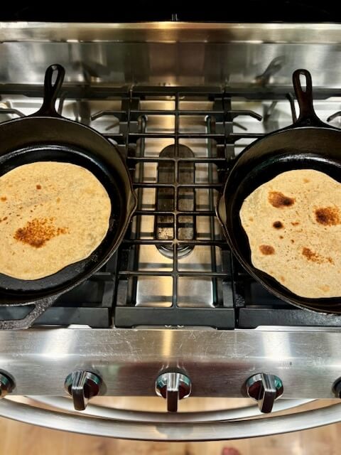 whole wheat tortillas in a cast iron on the stove