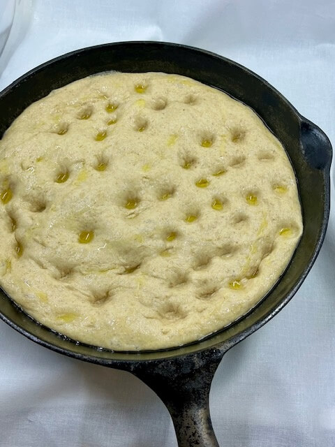 Fresh Milled Flour Pizza crust in a cast iron pan and poked like focaccia with oil