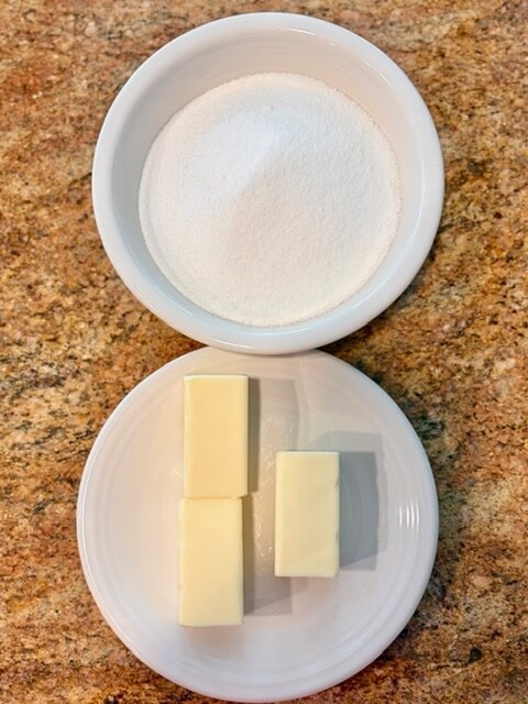 A bowl of sugar and a plate of butter on a counter for fresh milled flour banana bread