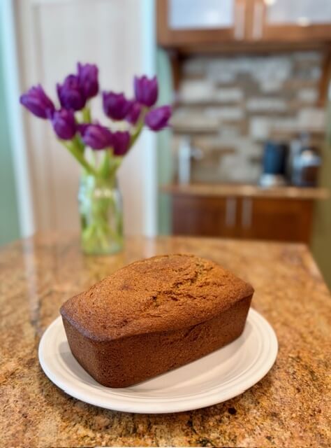 Fresh milled Banana Bread on the counter with purple flowers