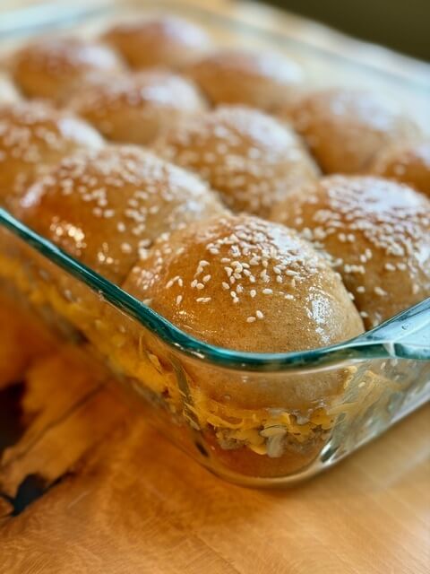 Cheeseburger sliders in a 9x13 pan made with fresh milled flour dinner rolls