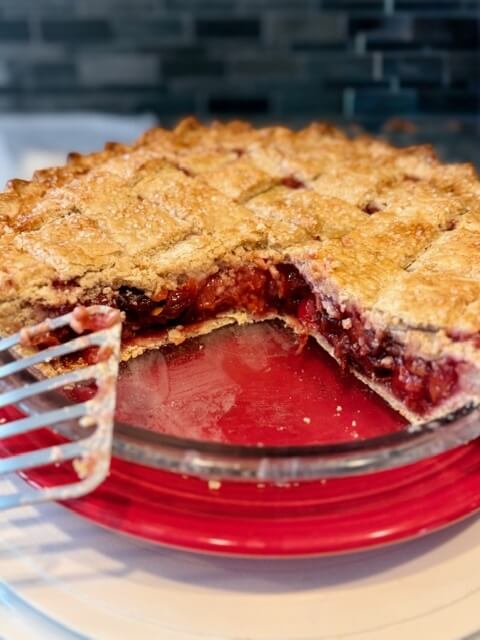 fresh Milled flour pie crust with cherry center and one piece cut out of the pie