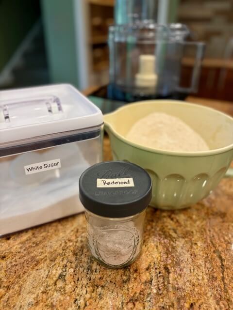 Bowl of sugar, jar of salt, and a bowl of fresh milled flour
