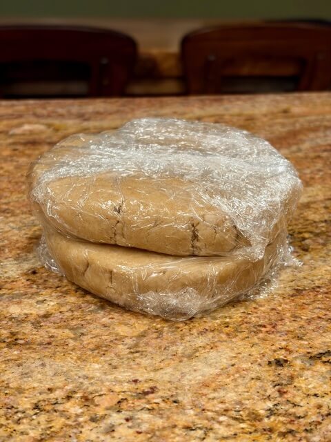 Two fresh milled flour pie crust wrapped in saran wrap