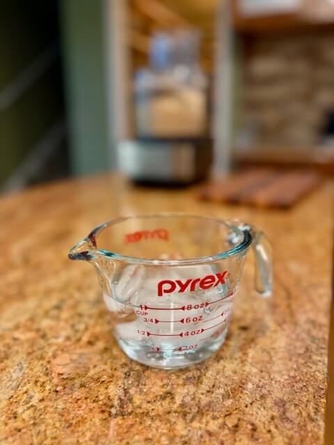 water in a measuring cup with ice cubes in it