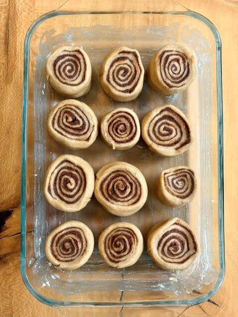 fresh milled cinnamon rolls before second rise in a pan