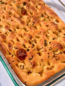 Fresh Milled Focaccia in a pan on a white tablecloth