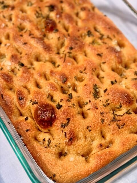 Fresh Milled Focaccia in a pan on a white tablecloth