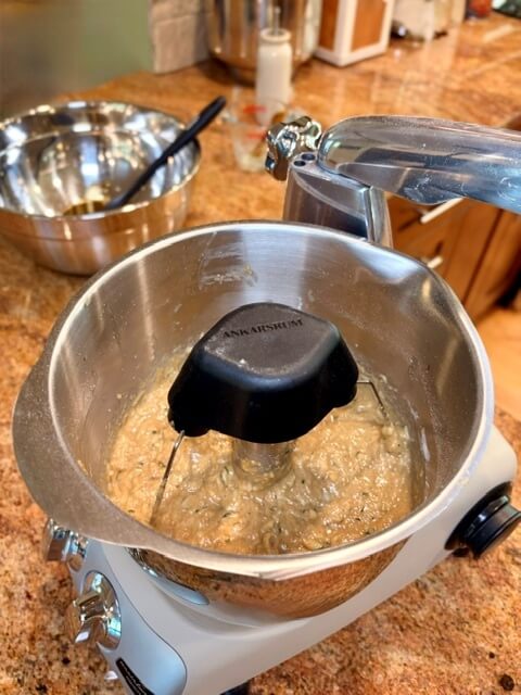 mixing bowl with fresh milled flour zucchini bread batter and bowl in the background