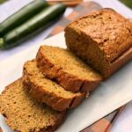 Fresh Milled Flour Zucchini Bread on a cutting board with zucchini and cinnamon stick in the background