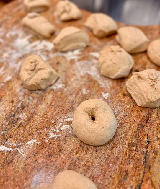 fresh milled flour bagels on the countertop and one has a hole in the middle