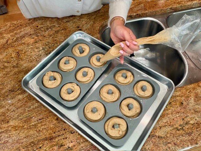 fresh milled flour apple cider donuts being piped into the donut pans