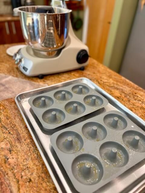donuts pans being sprayed for fresh milled flour apple cider donuts
